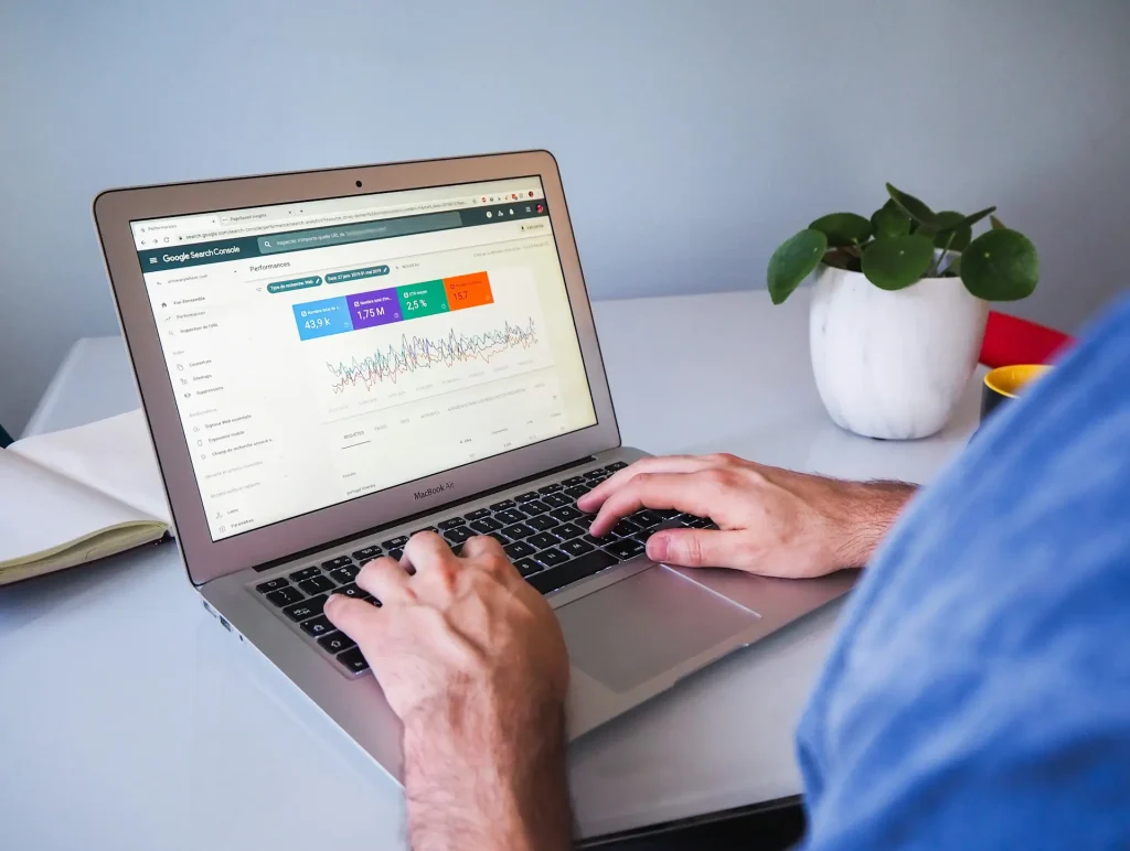 Website SEO consultant analyzing a site audit on a laptop, showing performance graphs and keyword data.